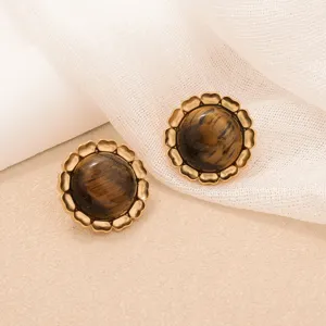 Macro detail of vintage tiger eye stud earrings with an elegant golden sun flower border