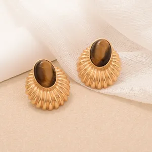 Detail view of vintage tiger eye stone stud earrings with golden sunburst ribbed texture