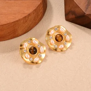 Nahaufnahme von Vintage-Goldohrringen mit braunem Tigerauge-Stein, Perlen und Strass