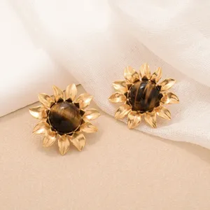 Detailed macro view of vintage sunflower earrings featuring tiger eye stone and gold finish
