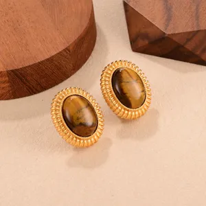 Gros plan détaillé des boucles d'oreilles vintage en œil de tigre avec bords dorés