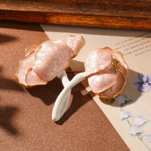 Detailed view of a vintage pink marbled flower brooch with gold edges and white stem.