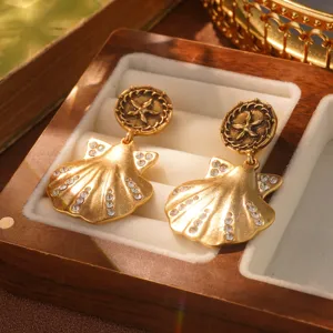 Close-up of vintage gold shell earrings with starfish and rhinestones in jewelry box