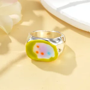 Gros plan d'une bague large argentée avec un design incrusté en émail abstrait