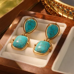 Macro view of vintage turquoise drop earrings with gold finish in a wooden jewelry box