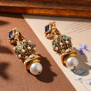 Close-up of vintage gold-tone earrings with pearls and blue crystals in a retro setting