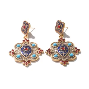 Macro view of vintage baroque palace earrings with blue enamel and red accents