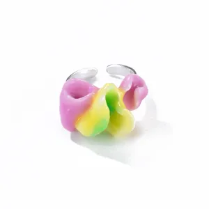 Vue détaillée d'une bague ouverte texturée avec un motif floral coloré en résine