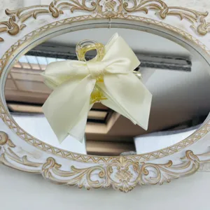 Elegant large cream satin bow hair claw clip displayed on a vintage ornate mirror base.