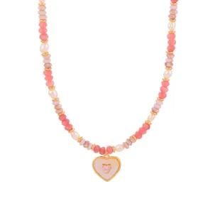 Close-up van een roze kralenketting met een gouden hartvormige hanger voor dames