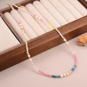 Gedetailleerde weergave van een kleurrijke kralenketting met kleine parels en gouden accenten