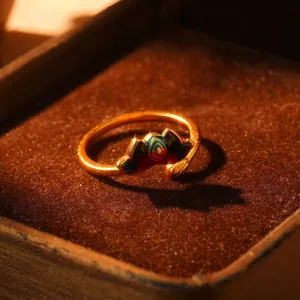 Close-up detail of a vintage style gold ring featuring vibrant rainbow enamel design