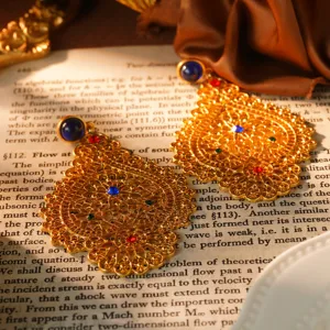 Vue détaillée de boucles d'oreilles dorées de style cour vintage avec pierres colorées.