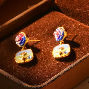 Gros plan de boucles d'oreilles style peinture à l'huile avec clous floraux colorés