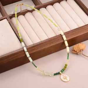 Detailweergave van frisse groene kralenketting met gouden sterhanger op sieradendienblad