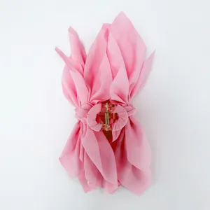 Top-down detail of a pink chiffon fabric bow hair claw clip with voluminous layers.