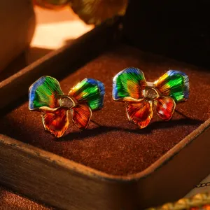Detailed macro shot of vintage rainbow enamel butterfly stud earrings with crystal center