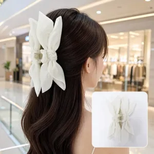 Back view of a woman wearing an elegant white fabric bow hair claw clip in a mall