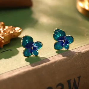 Nahaufnahme von blauen Emaille-Ohrringen im Vintage-Hofstil auf einem Buch