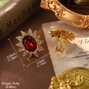 Close-up detail of vintage sunburst earrings with red gemstone and rhinestones