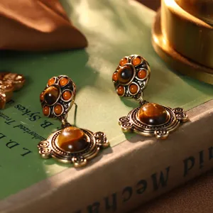 Detaillierte Nahaufnahme goldener Vintage-Ohrringe mit stilvollen Tigerauge-Steinen