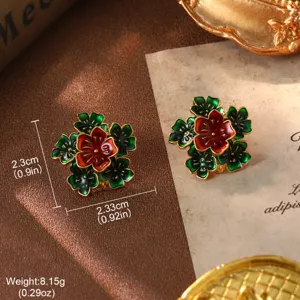 Macro view of vintage floral enamel earrings with red and green petals and gold borders