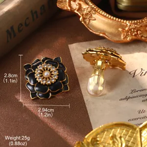 Close-up view of vintage black enamel flower earrings with pearls and size annotations
