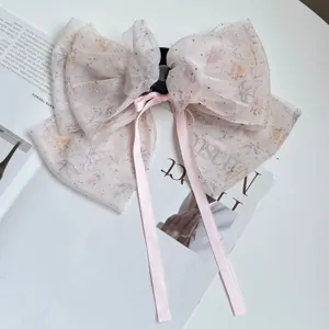 Detail of elegant chiffon floral bow hair clip with rhinestones and long ribbons