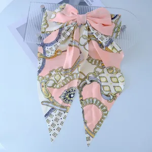 Detailed macro view of smooth fabric hair clip featuring elegant gold chain print
