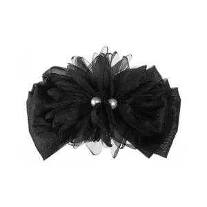 Dettaglio dell'elegante molletta per capelli in tessuto nero con fiore 3D e perle.