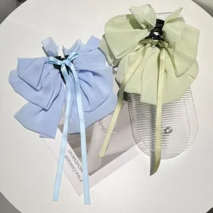 Close-up of light blue and pale green chiffon bow hair clips with elegant hanging ribbons