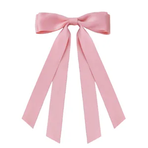 Detailed view of a sweet pink satin ribbon bow hair clip on a clean white background.