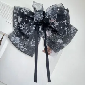 Close-up of floral chiffon bow hair claw clip with rhinestones and long ribbons.
