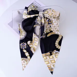 Detailed macro view of the silky Baroque pattern print bow hair clip with long ribbons