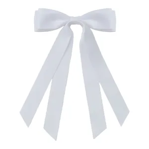 Close-up of white oversized satin ribbon bow hair clip with long fluttering tails