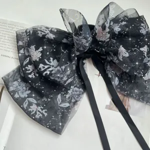 Close-up of a multi-layer floral chiffon bow hair clip with sparkling rhinestones