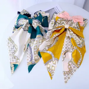 Detailed macro shot of elegant satin hair bows with luxury chain print and long ribbons