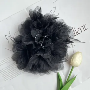 Detailansicht einer eleganten schwarzen Stoffblumen-Haarklammer mit Straußenfederbesatz