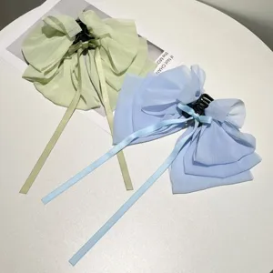 Detail of French style chiffon bow hair clips with long ribbons in light colors