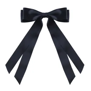 Detailed view of a large black satin bow hair clip with elegant long ribbon tails.