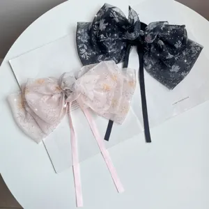Close-up of elegant floral chiffon hair bows with rhinestones and long ribbons