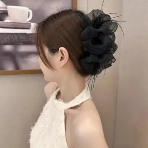 Large black mesh cloud hair claw clip with feathers worn on elegant updo hairstyle