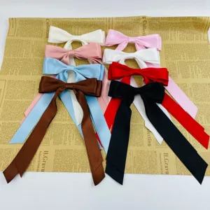 Detailed macro view of elegant satin ribbon bow hair clips in various vibrant colors.