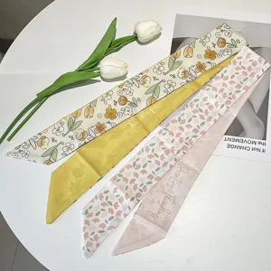 Close-up view of French vintage floral and letter print long silk-feel hair ribbons