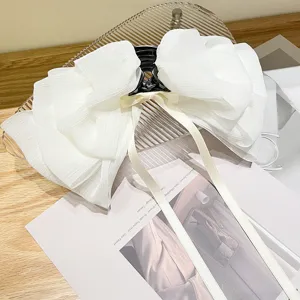Close-up of white chiffon bow hair claw clip with pleated fabric and ribbon detail