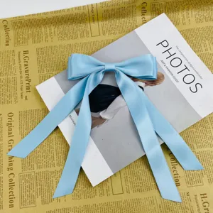 Detailed shot of a light blue satin bow hair clip with long streamers on a magazine