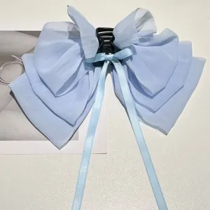 Detail view of a light blue textured chiffon bow hair claw with long silk ribbons.