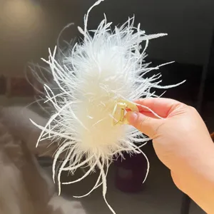 Detail view of large white ostrich feather hair claw clip for elegant hairstyles