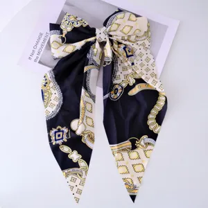 Detailed view of the elegant chain-patterned silky bow hair clip with long streamers.