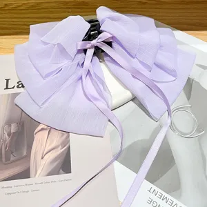 Close-up detail of a soft purple chiffon gauze bow hair claw clip with long ribbons